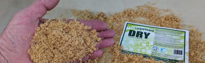 Hand holding nutrient-rich organic fertilizer with packaging nearby.