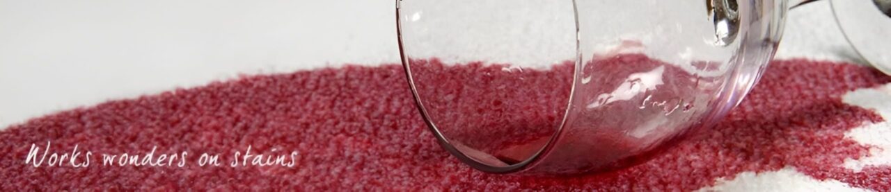 A clear glass cup tipped over on a red textured surface.