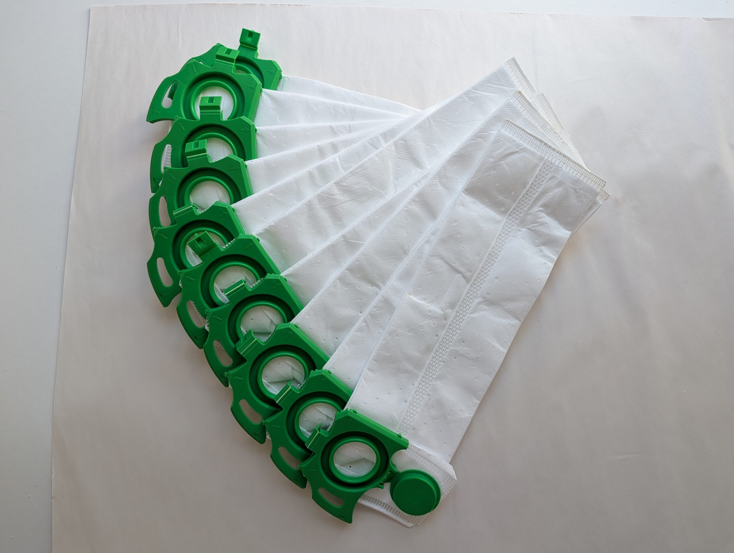 Set of white cloths with green plastic clips arranged in a row.